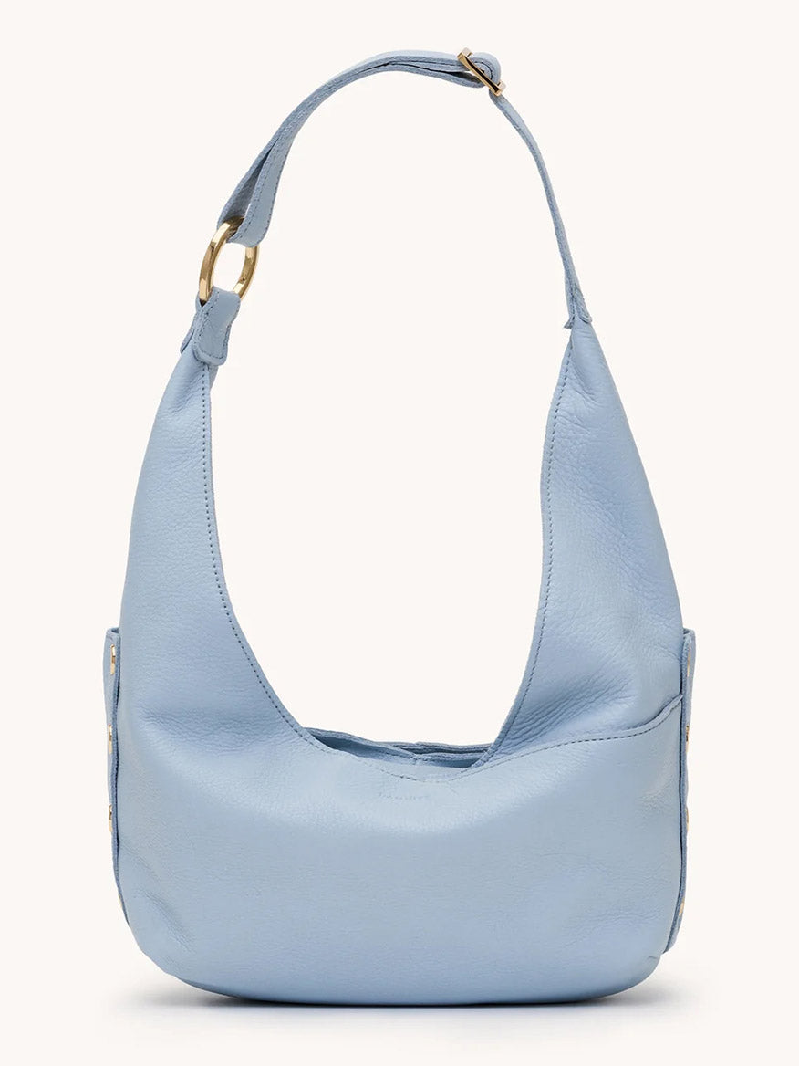 The Hammitt Los Angeles Tom Zip Medium in Hazy Blue/Gold is a compact hobo bag with pebbled leather, a short wide adjustable strap, and gold buckle details, shown on a plain background.