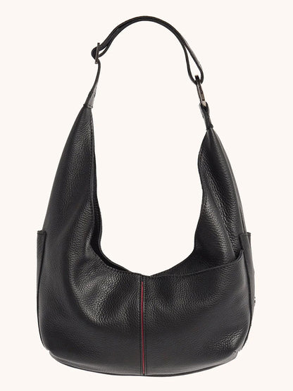 The Hammitt Los Angeles Tom Zip Medium in Black/Gunmetal is a black pebbled leather hobo bag with a wide adjustable shoulder strap, a slouchy shape, and subtle vertical red stitching down the front center.