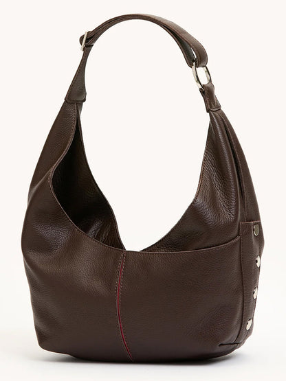 The Hammitt Los Angeles Tom Zip Medium in Espresso Pebble/Silver, a shoulder bag with a wide strap, silver hardware, and visible red front stitching, stands upright on a neutral background.