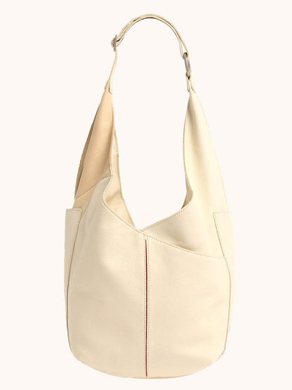 The Hammitt Los Angeles Tom Zip in Coastal Cream is a beige leather hobo bag with a Coastal Pebble finish, wide adjustable strap, and soft curved design.