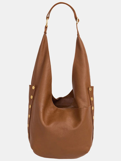 The Hammitt Los Angeles Tom Zip in Mahogany Pebble is a pebbled leather hobo bag with an adjustable wide strap, gold stud accents, an open top, and a slouchy design.