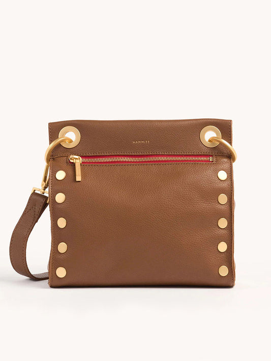 Explore the Hammitt Los Angeles Tony Medium Crossbody Bag in Mahogany Pebble w/Red Zip, featuring gold studs, a vibrant red zippered pocket, large gold eyelets at the top, and an adjustable crossbody strap for versatile wear.