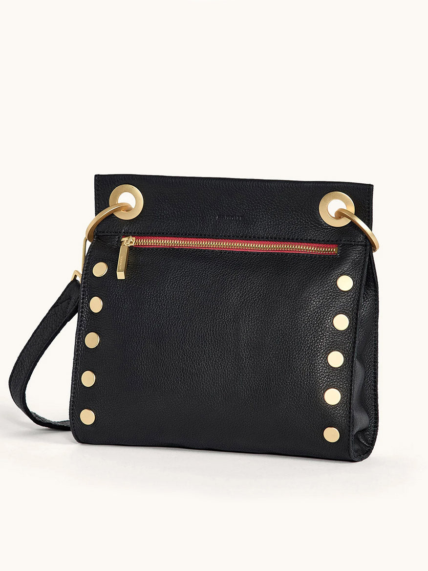 The Hammitt Los Angeles Tony Medium Crossbody Bag in Black/Brushed Gold/Red Zip features black leather, gold studs and hardware, a red front zipper pocket, and a detachable strap—the ideal everyday accessory.