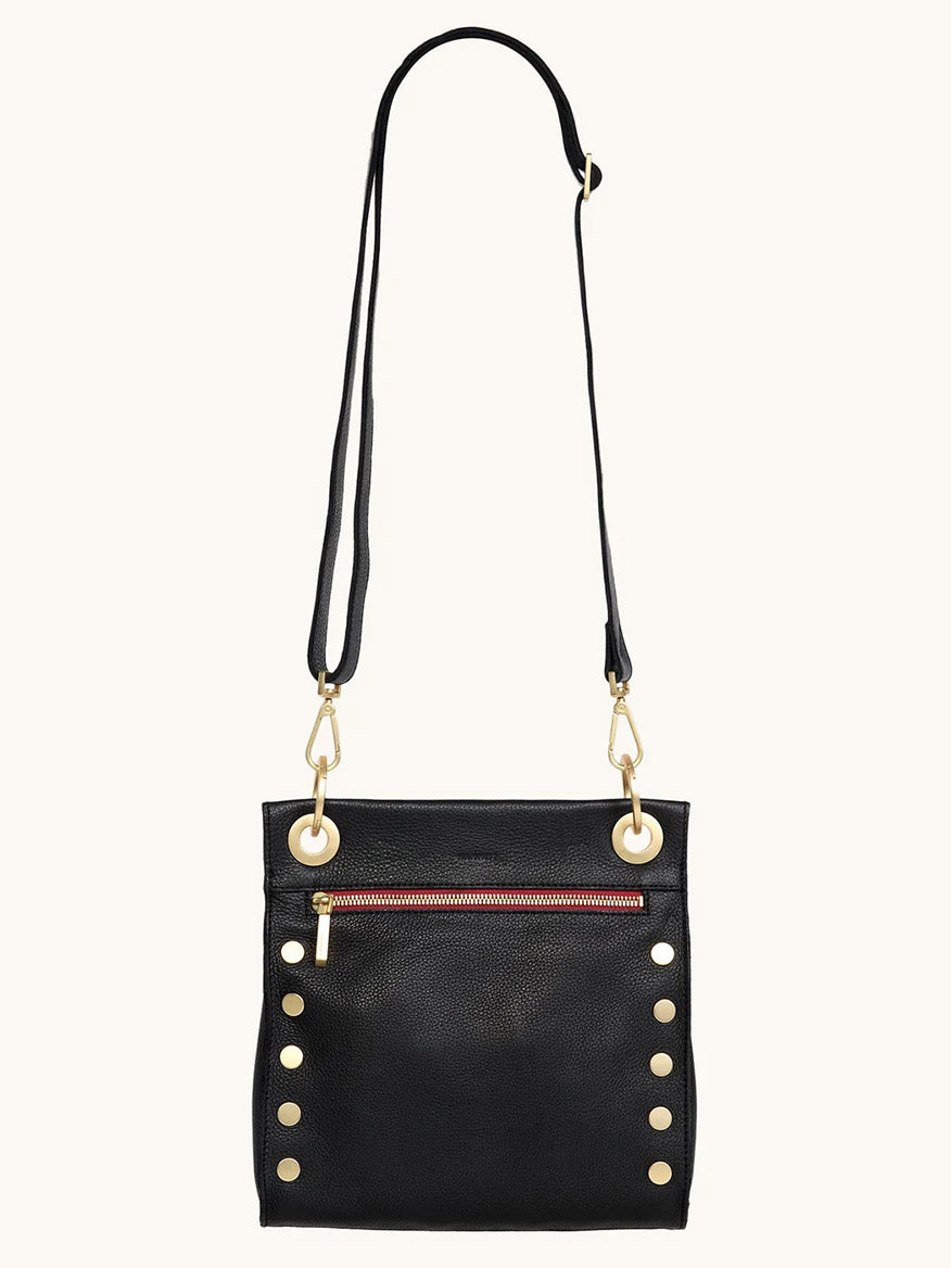 The Hammitt Los Angeles Tony Medium Crossbody Bag in Black/Brushed Gold/Red Zip features gold studs, a front pocket with a red zip, and an adjustable strap—ideal as your new everyday crossbody.