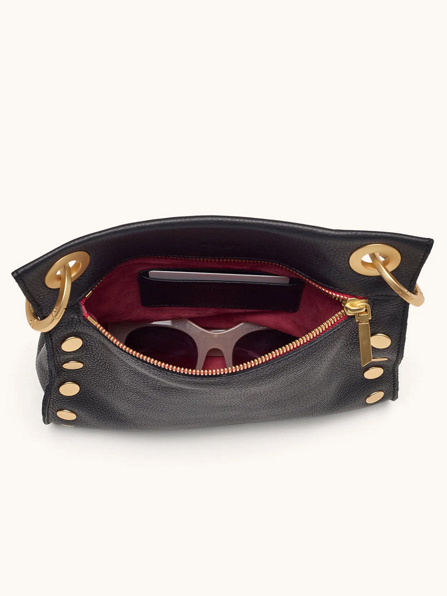 Top view of the Hammitt Los Angeles Tony Medium Crossbody Bag in Black/Brushed Gold/Red Zip, featuring gold hardware, a red lining, and space for everyday essentials like your smartphone and sunglasses.