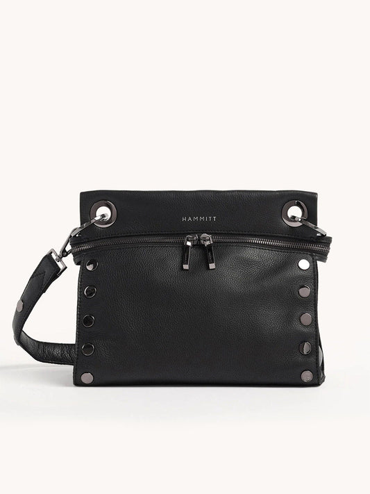 The Hammitt Los Angeles Tony Signature Medium Crossbody in Black & Gunmetal is crafted from black pebbled leather with silver studs, a front zipper pocket, and an adjustable shoulder strap. It features a top-embossed logo and offers versatility for use as a crossbody bag.