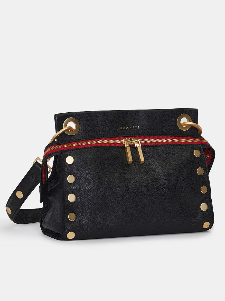 Hammitt Los Angeles Tony Signature Medium Crossbody in Black with gold stud accents, red zipper detail, adjustable shoulder strap, and commemorative details.