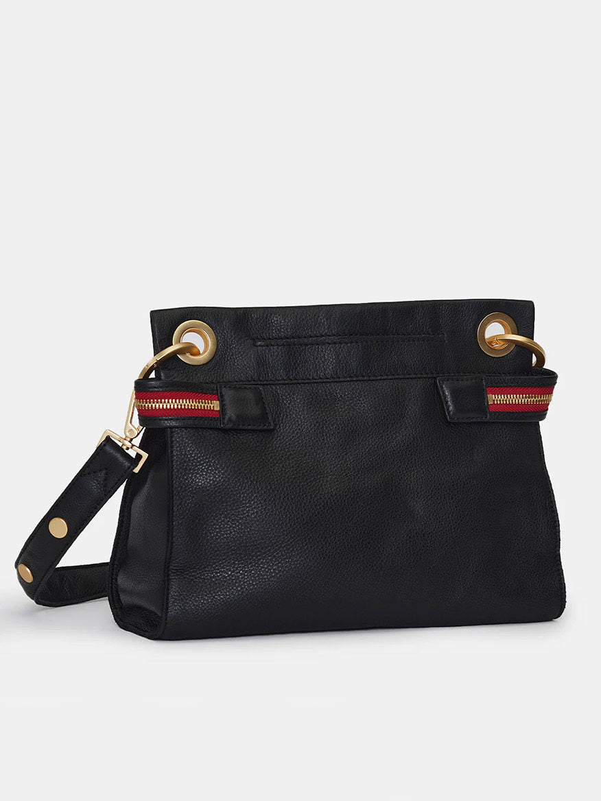 A limited edition black leather handbag with gold grommet details, red and green striped zippers, and a detachable strap featuring gold studs against a white background. This Hammitt Los Angeles Tony Signature Medium Crossbody in Black also boasts commemorative details that make it truly special.