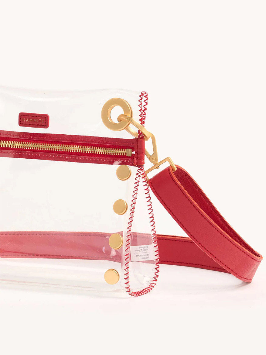 The Hammitt Los Angeles Tony Small Crossbody Bag in Clear Poppy Red features bold red edges, a matching adjustable strap, sleek gold hardware, and a convenient front zippered pocket, combining style and functionality with stadium-approved design.