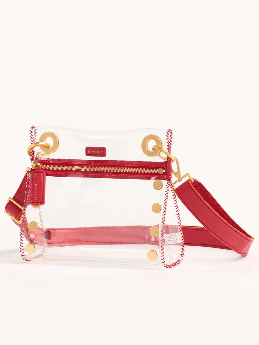 The Hammitt Los Angeles Tony Small Crossbody Bag in Clear Poppy Red features stadium-approved design, red trim, gold buttons, and an adjustable crossbody strap for convenience.