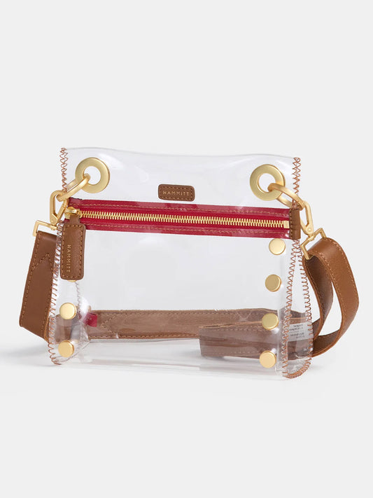 The Hammitt Los Angeles Tony Small Crossbody Bag in Clear Mahogany Pebble & Red Zip features brown leather trim, gold hardware, a red zipper, and an adjustable strap—stadium-approved and shown against a plain background.