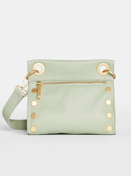 A Hammitt Los Angeles Tony Small Crossbody Bag in Cypress Sage with gold hardware and a front zipper, displayed against a light gray background.