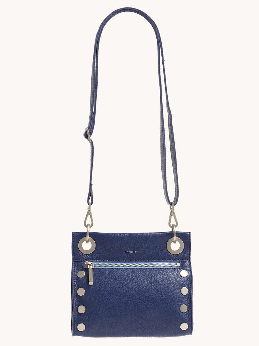 The Hammitt Los Angeles Tony Small Crossbody Bag in Jazz Blues is made from pebbled leather, adorned with silver hardware and large grommets. It features an adjustable strap and a front zipper pocket for convenience.