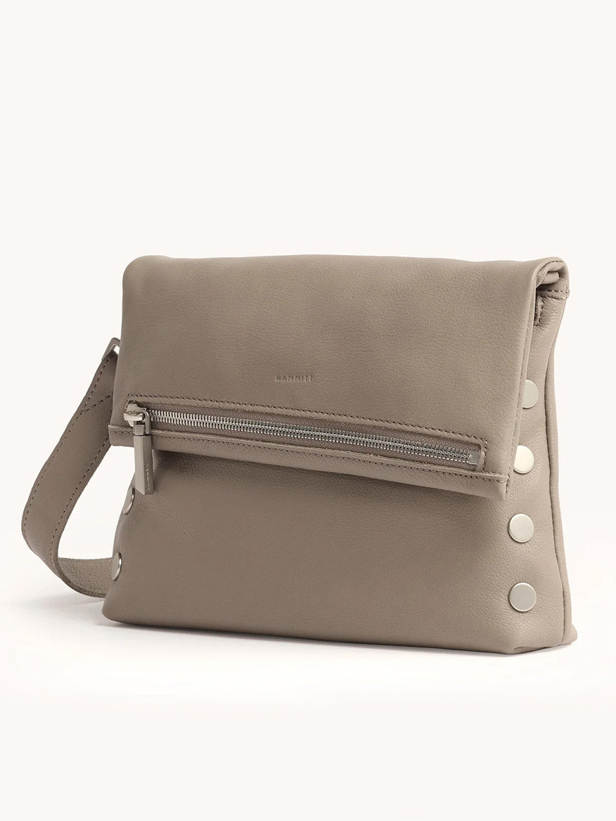 The Hammitt Los Angeles VIP Medium Clutch in Pewter Pebble features a front zipper pocket, silver rivet details on the side, and a matching removable crossbody strap, shown against a plain background.