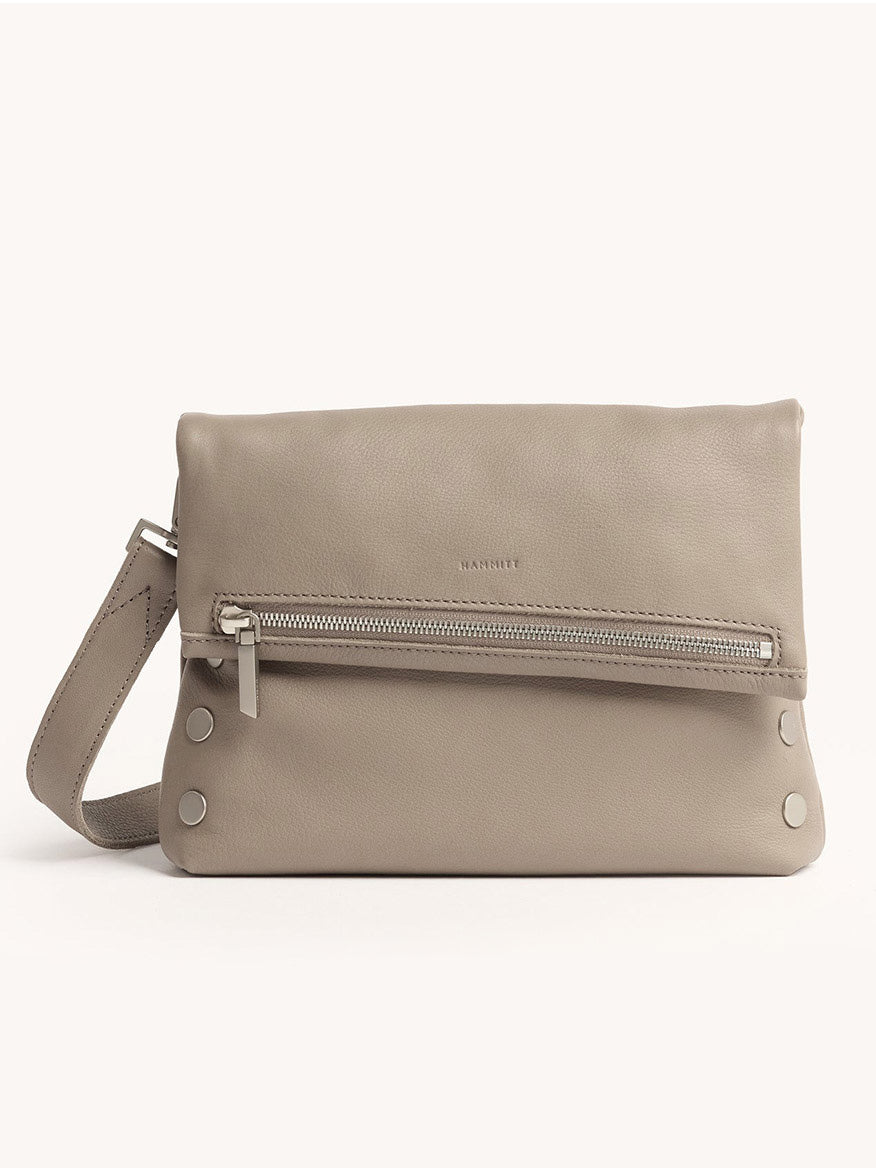 The Hammitt Los Angeles VIP Medium Clutch in pewter pebble leather features a wrist strap, front zipper pocket, silver hardware, and removable crossbody strap, shown against a plain light background.
