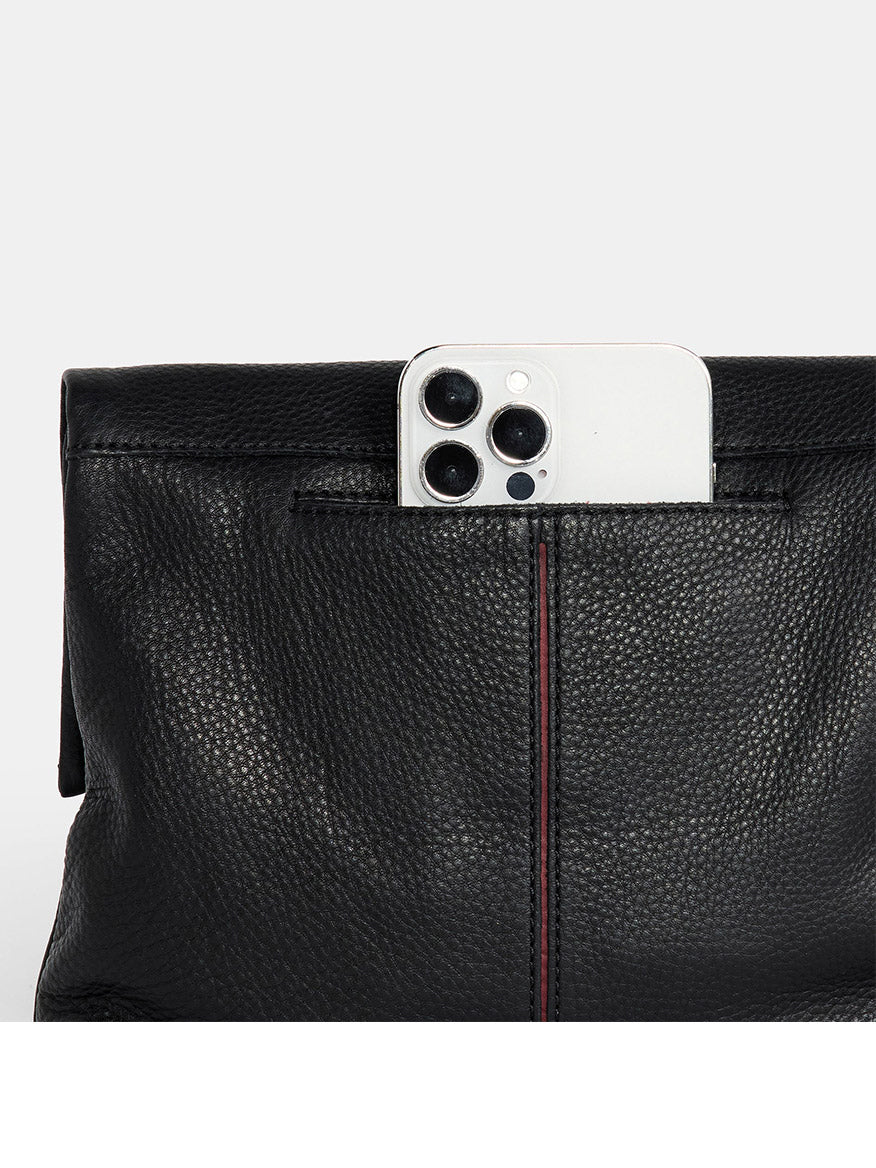 The Hammitt Los Angeles VIP Medium Clutch in Black, featuring pebbled leather with a white smartphone partially inserted in the top pocket, exudes sophistication and style.