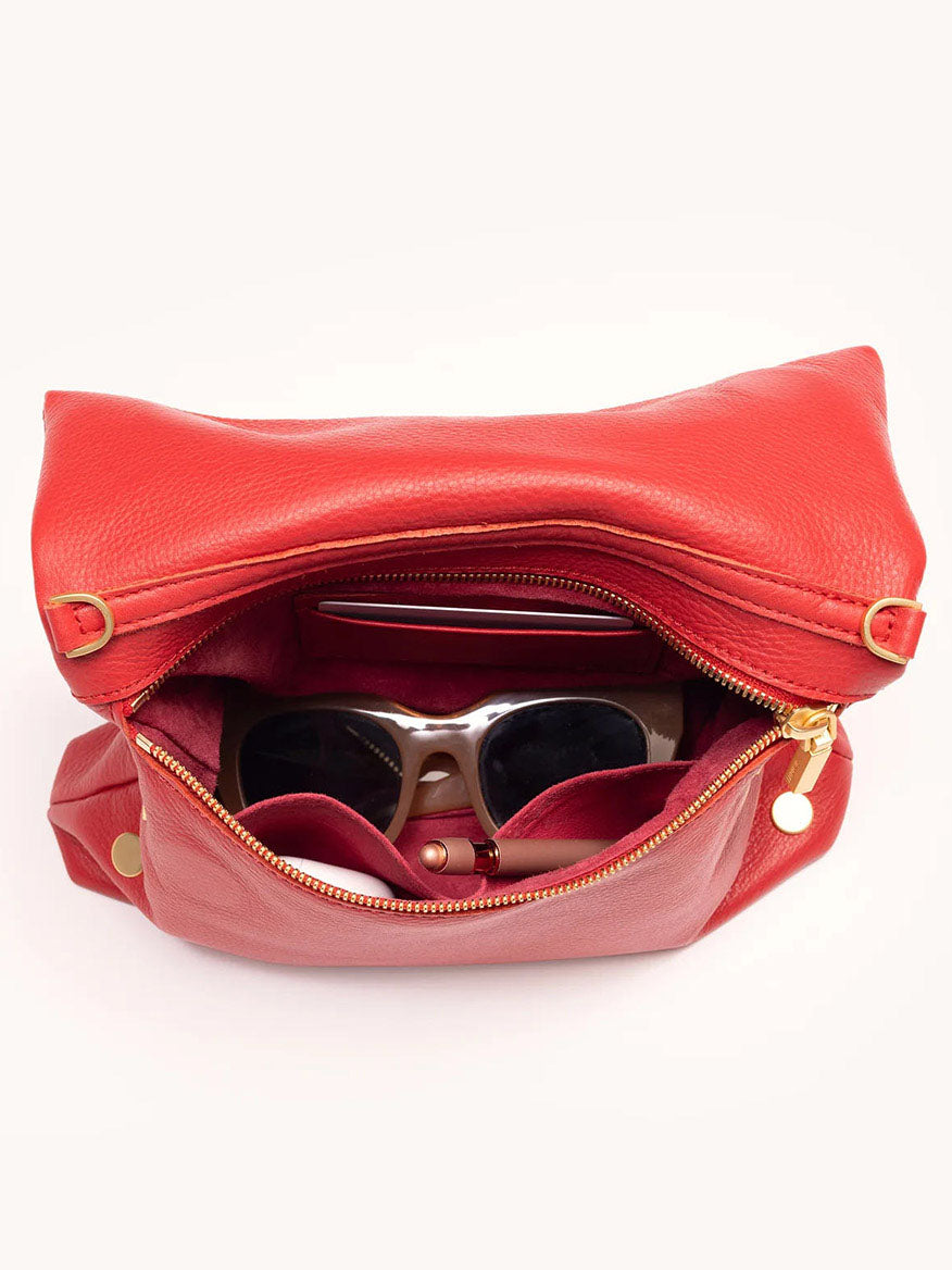 Revealing sunglasses inside, the Hammitt Los Angeles VIP Medium Clutch in Poppy Red features a chic crossbody style and a zippered pocket.