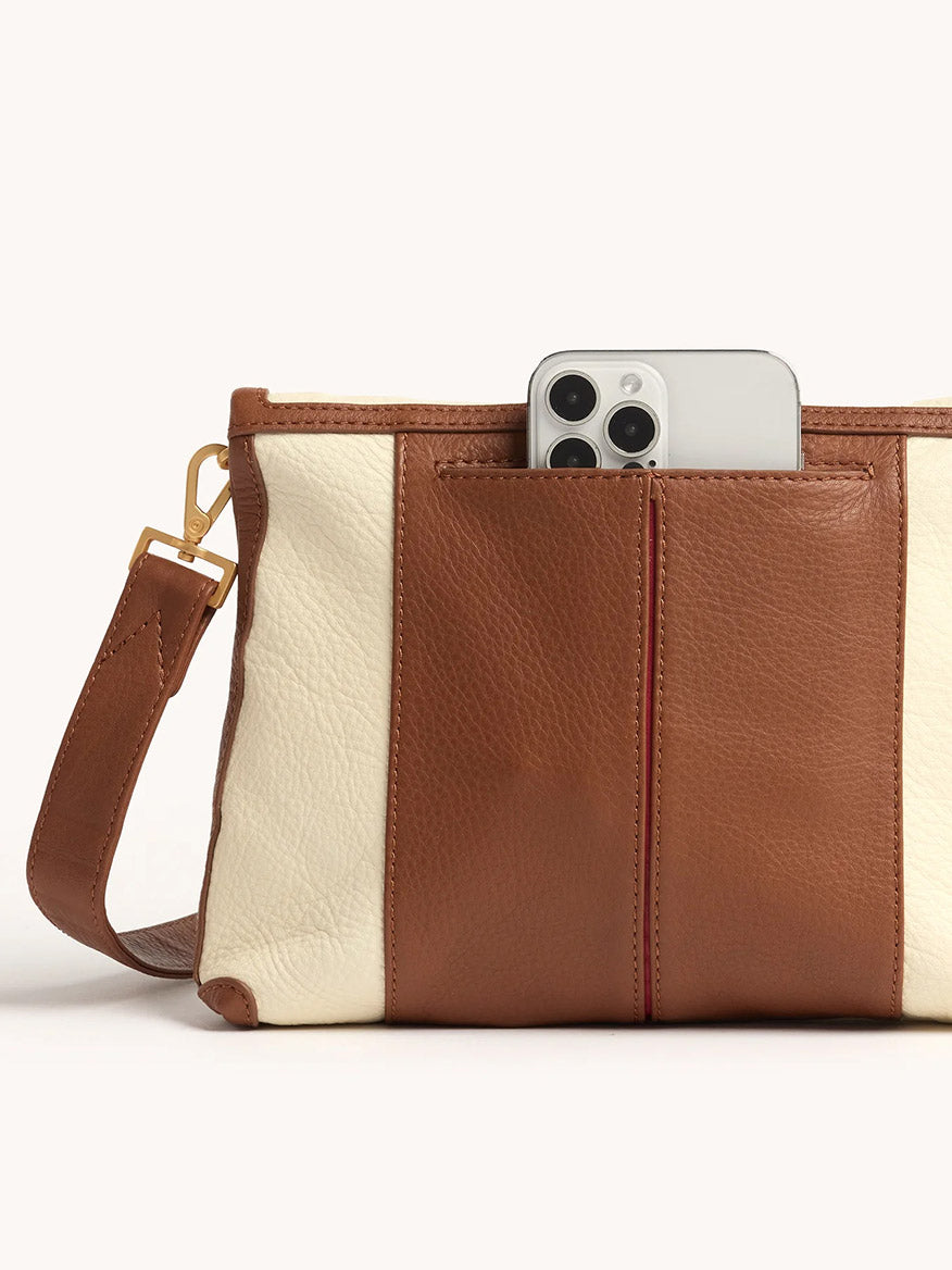 The Hammitt Los Angeles VIP Medium Clutch in Courtyard Cream is a brown and cream leather bag with a removable crossbody strap and a phone partially visible in the front pocket.