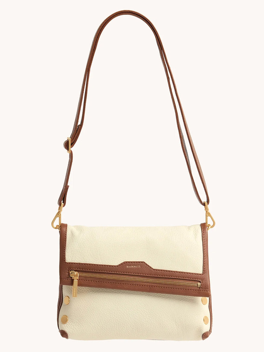 The Hammitt Los Angeles VIP Medium Clutch in Courtyard Cream features a cream body with brown trim, front zipper pocket, gold hardware, and a removable crossbody strap for versatile styling.