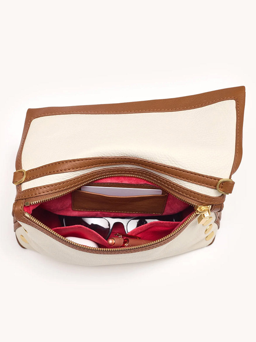 The Hammitt Los Angeles VIP Medium Clutch in Courtyard Cream features cream and brown leather with gunmetal rivets, a top flap revealing a red interior, card slot, and zippered compartment.