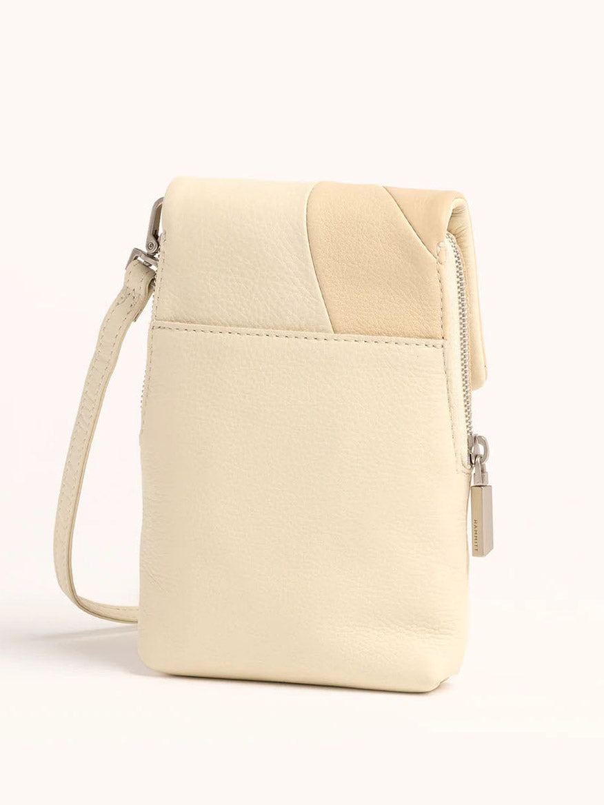 The Hammitt Los Angeles VIP Mobile in Coastal Cream is a beige leather crossbody bag featuring a silver zipper, adjustable strap, and a subtle patchwork design reminiscent of coastal pebbles on the top corner.