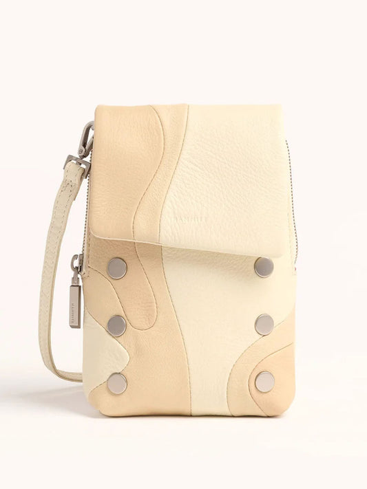 The Hammitt Los Angeles VIP Mobile in Coastal Cream is a compact crossbody bag featuring a patchwork design in beige and cream tones with metal studs and a zippered closure.