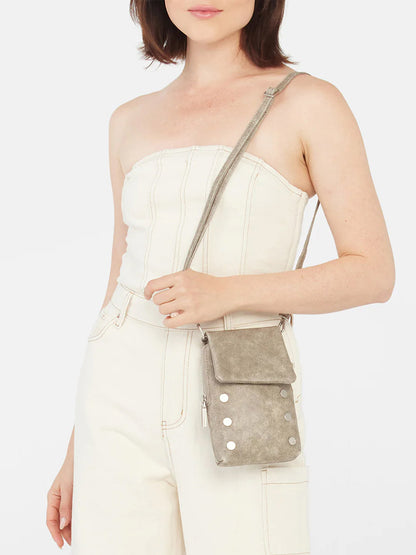 Woman wearing a strapless white jumpsuit with a Hammitt Los Angeles VIP Mobile in Pewter crossbody bag.