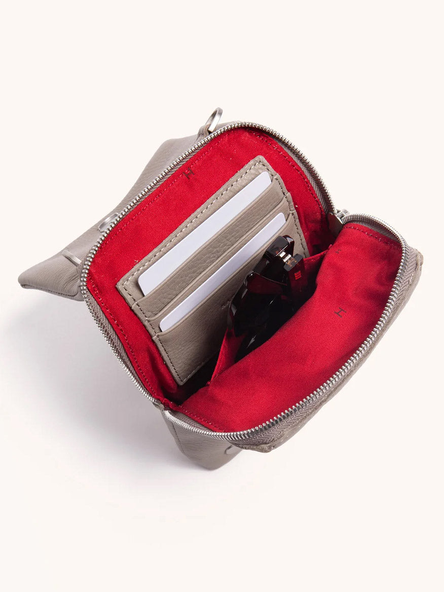The Hammitt Los Angeles VIP Mobile in Pewter/Brushed Silver is a compact pebbled leather bag featuring a zippered pouch, red interior with card slots, and space for two cards and sunglasses.