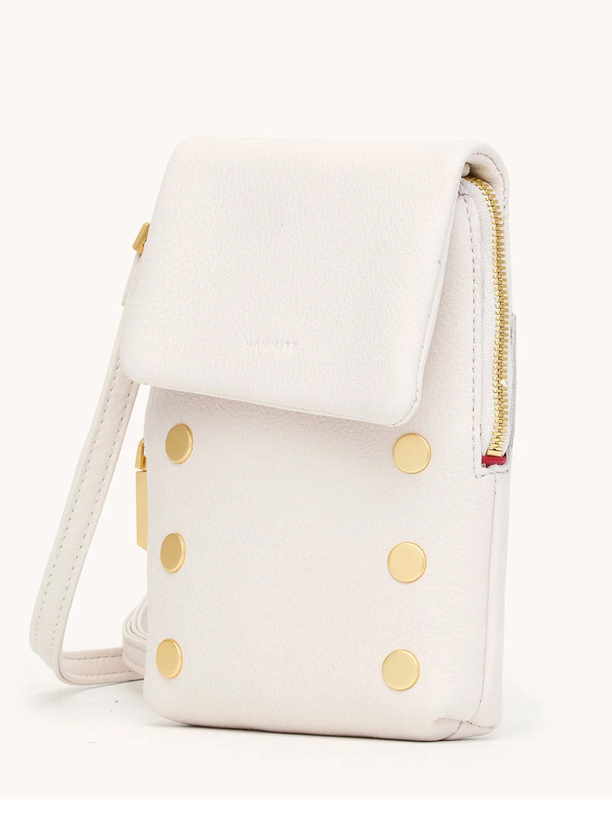 The Hammitt Los Angeles VIP Mobile in Calla Lily White/Brushed Gold is a compact white crossbody bag featuring pebble leather, a flap closure, brushed gold studs on the front, and a side zipper detail.