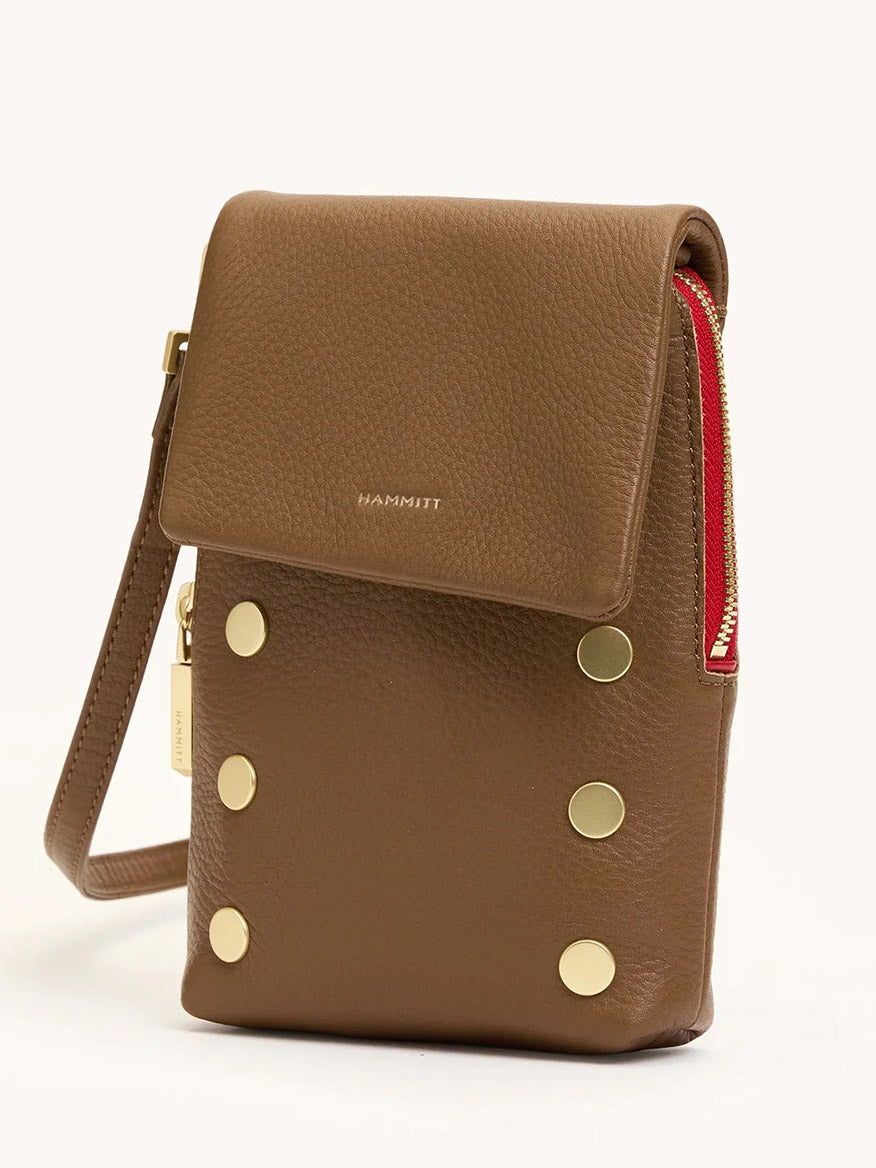 The Hammitt Los Angeles VIP Mobile in Mahogany Pebble features brushed gold studs, a red side zipper, an embossed front flap, a wrist strap, and a handy cellphone pocket.