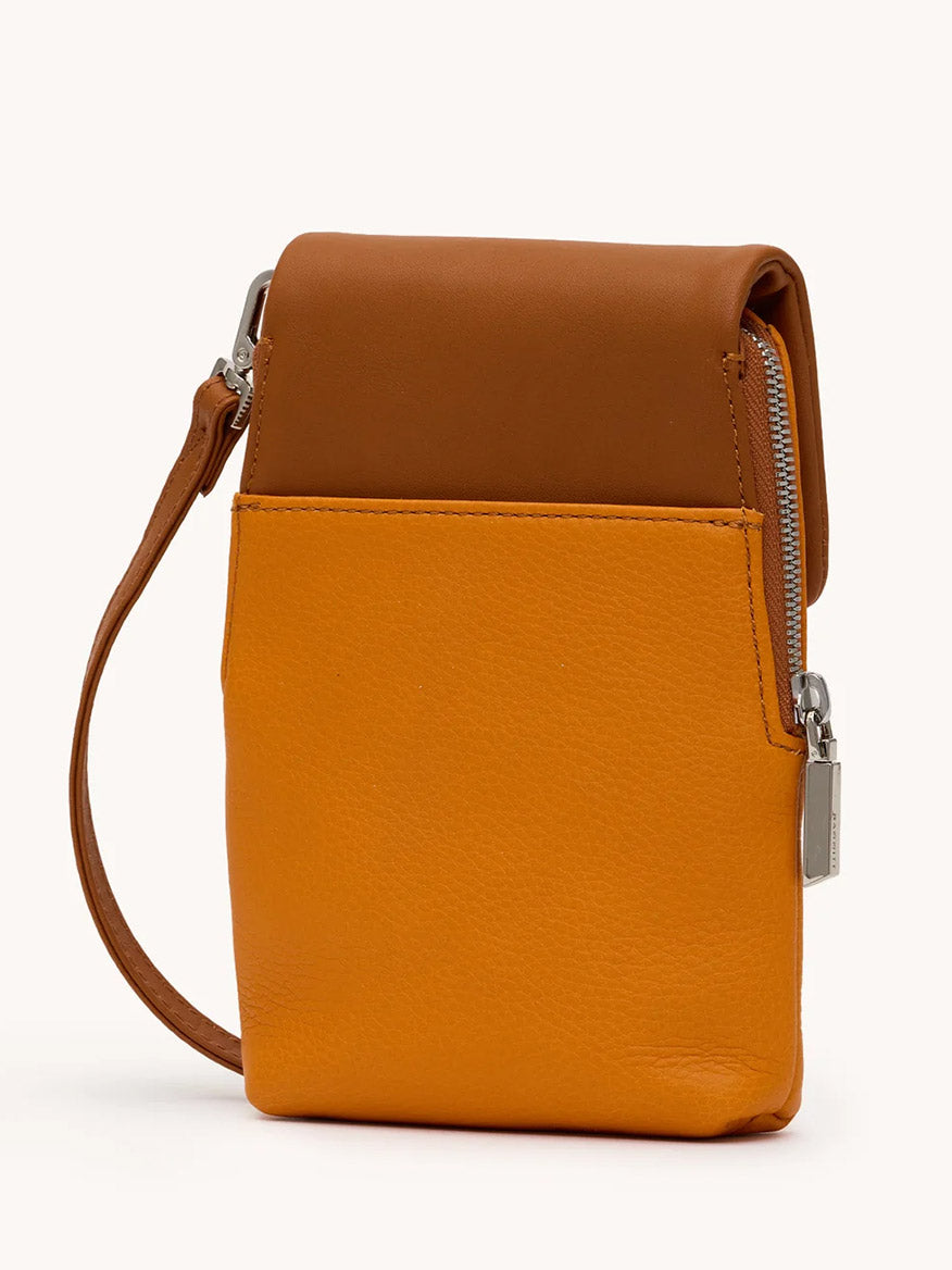 The Hammitt Los Angeles VIP Mobile in Tailored Tangerine/Silver is a small, rectangular leather cellphone pocket handbag with a wrist strap, front pocket, and side zipper closure in brown and orange tones.