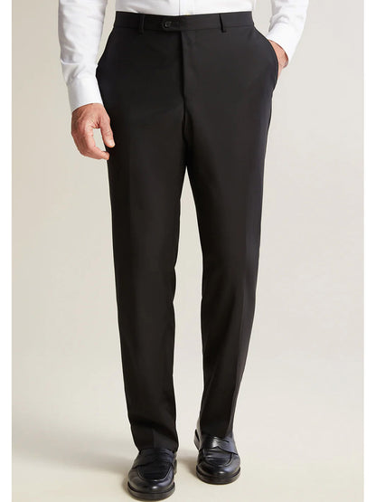 A person outfitted in the Hickey Freeman (Heritage Gold) Black Infinity Suit, crafted from Super 140s Infinity wool sourced from the Carlo Barbera mill, stands against a plain background. They are complemented by a crisp white shirt, black dress pants, and polished black shoes.