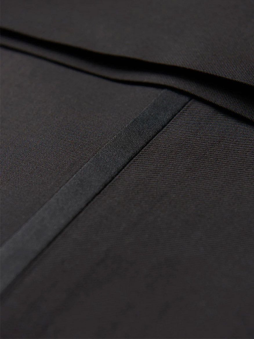 Close-up of a black fabric with delicate stitching and a subtle sheen, reminiscent of the luxurious craftsmanship seen in the Hickey Freeman (Heritage Gold) Black Peak Lapel B-Body Tuxedo.