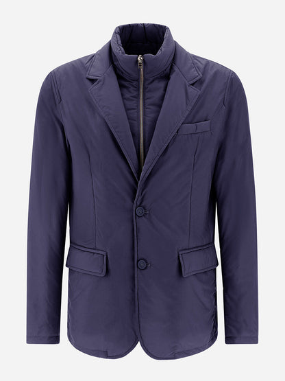 The Herno Blazer in Ecoage, in a shade of new blue, is designed with two buttons, flap pockets, and a notched lapel. Made from recycled nylon microfibre, it includes a zip-up quilted inner lining for additional warmth.