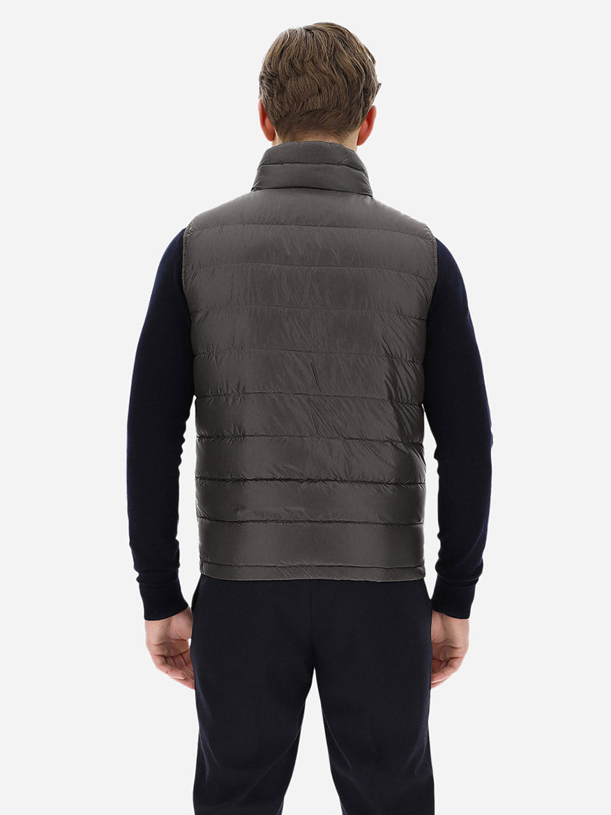 The back view of a man wearing a Herno Reversible Nylon Ultralight Waistcoat in Navy/Grey made with goose down feathers.