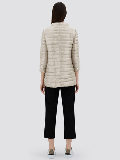 Seen from behind, a person with long hair wears the Herno Rossella A-Shape Jacket in Chantilly, paired with black cropped pants and gray slip-on shoes, set against a plain background.