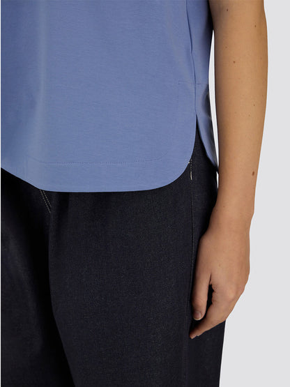 A person is seen from mid-torso to thigh wearing the Herno Superfine Cotton Stretch T-Shirt in Light Blue and dark pants, with their right arm relaxed by their side.