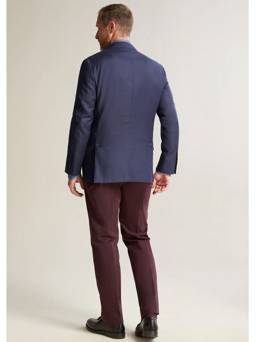 The back view of a man wearing a Heritage Gold Navy Hopsack Global Guardian Blazer and maroon pants, showcasing his American-made attire.