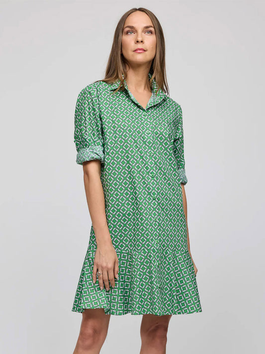 A woman wears the Hinson Wu Adeline Long Sleeve Chain Link Dress in Green Multi, featuring a green pattern, collared neckline, refined cotton fabric, and rolled-up sleeves, standing against a plain light gray background.