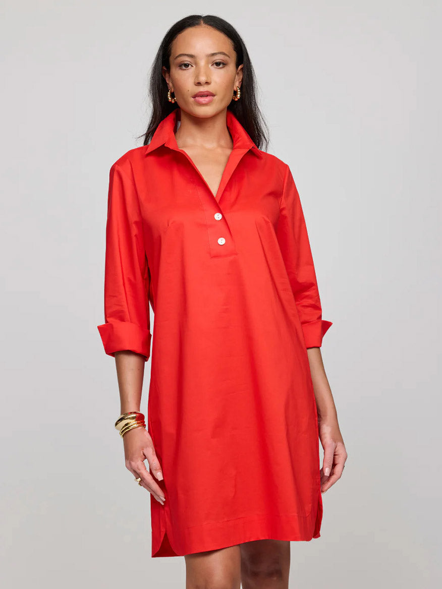 A woman wears the Hinson Wu Aileen 3/4 Sleeve Button Back Dress in Scarlet, a loose-fitting, knee-length red dress with rolled-up sleeves and a collar, standing against a plain light background.