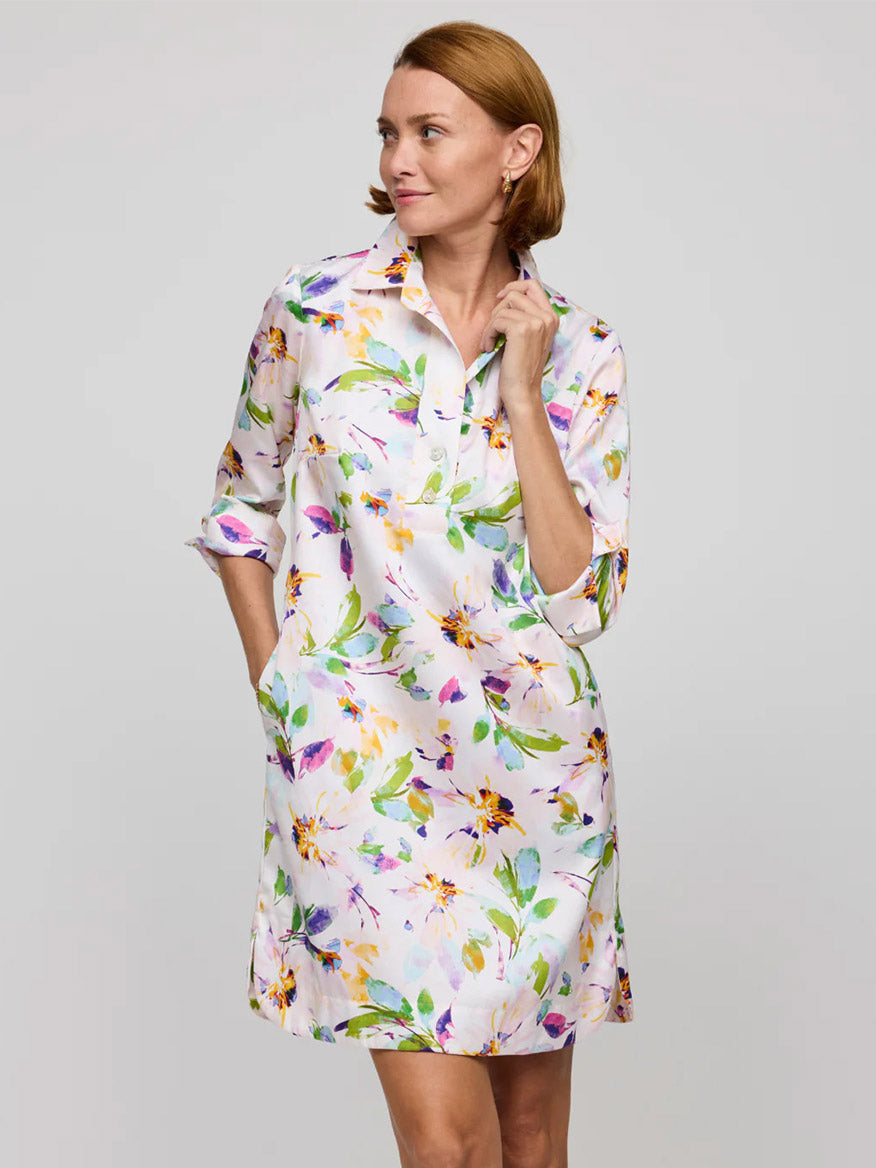 A woman wearing the Hinson Wu Aileen 3/4 Sleeve Garden Sateen Dress in Garden Multi stands with one hand in her pocket and the other touching her chin, looking to the side.