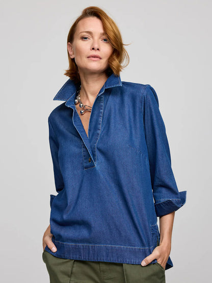 A person with short red hair wears the Hinson Wu Aileen 3/4 Sleeve Denim Shirt in Dark Wash and a necklace, standing with hands in pockets against a plain backdrop.