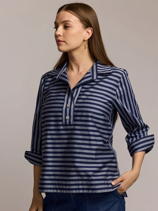 A woman wears the Hinson Wu Aileen 3/4 Sleeve Classic Stripe Shirt in French Grey/Midnight with blue jeans, standing against a plain background.