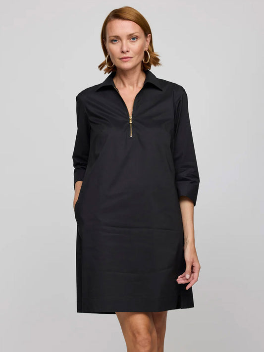 A woman models the Hinson Wu Alessa 3/4 Sleeve Dress in Black, a knee-length stretch cotton dress with a gold zippered collar, standing against a plain background.