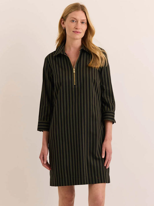 A woman stands facing forward wearing the Hinson Wu Alessa 3/4 Sleeve Classic Stripe Dress in Oregano/Black, featuring black and olive green vertical stripes, premium cotton fabric, a gold zipper detail at the collar, and three-quarter sleeves.