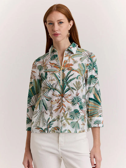 A woman with long red hair wears the Hinson Wu Alessa 3/4 Sleeve Top in Amazonian Print and white pants, standing against a plain light background.