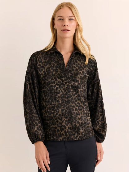 A woman stands against a plain background wearing the Hinson Wu Arianna Long Sleeve Animal Print Top in Animal Print, paired with dark pants, looking at the camera.