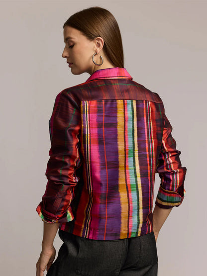 A woman is seen from the back wearing the Hinson Wu Astrid Long Sleeve Textured Stripes Shirt in Multi, featuring vibrant textured stripes, paired with dark pants against a neutral background.