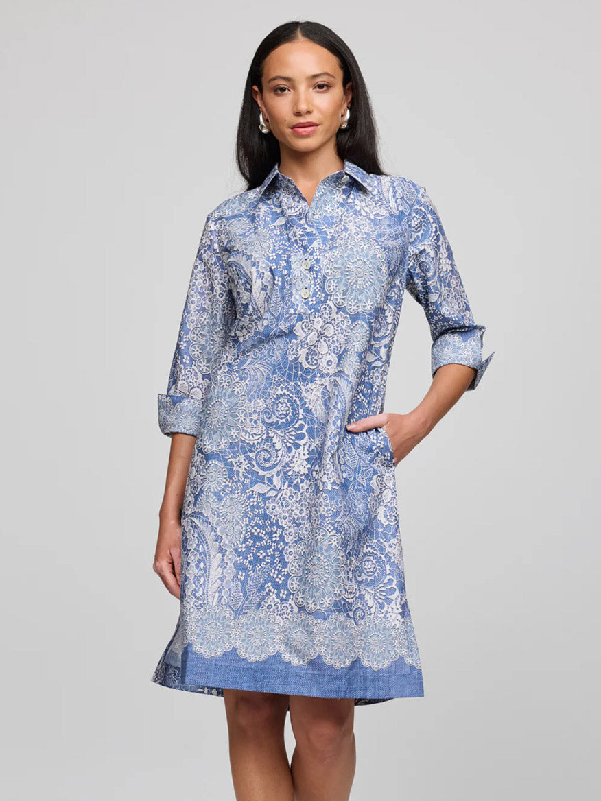 A woman stands against a plain background, wearing the Hinson Wu Charlotte 3/4 Sleeve Lace Print Dress in Blue/Ecru, with rolled-up sleeves and hands in her pockets.