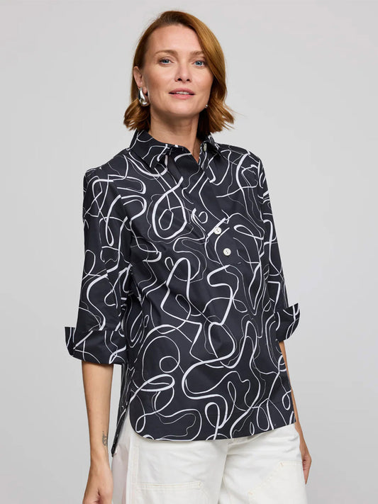 A woman wearing the Hinson Wu Charlotte 3/4 Sleeve Ribbon Shirt in Black/White with white pants stands against a plain gray background.